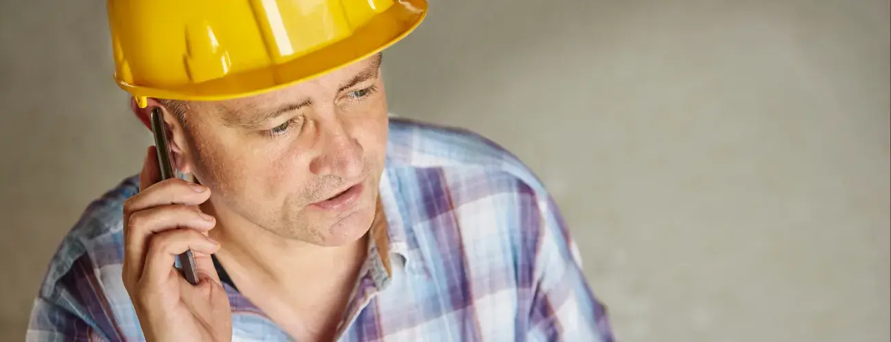 Handwerker am Telefon meldet Schaden